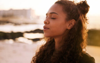 A woman meditates on the beach.