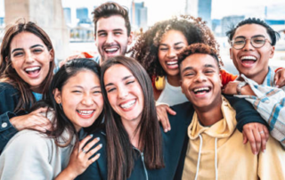 A group of youths smiling and embracing each other.